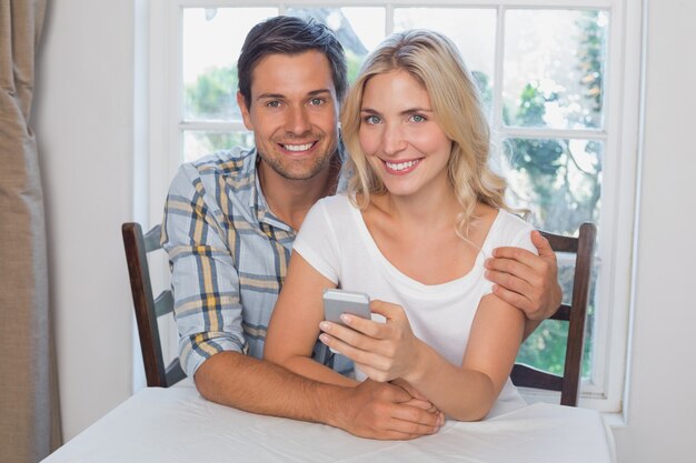 Loving couple reading text message together at home