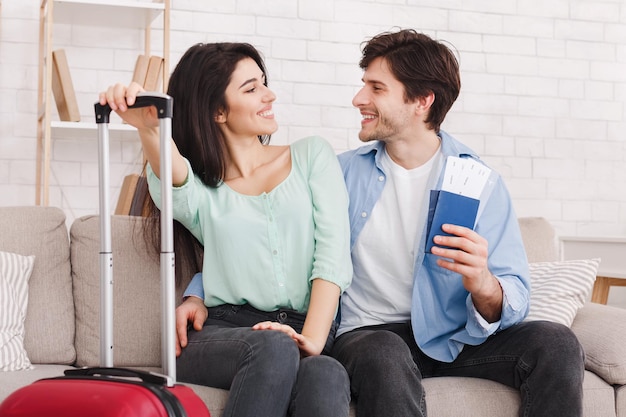 Photo loving couple ready for trip holding passports and tickets