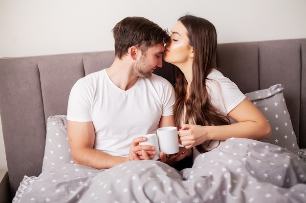 Loving couple relaxing in bed at home