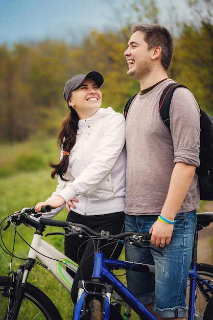 Loving couple ride by bicycles