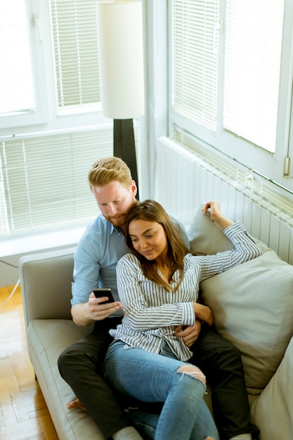 Loving couple in the room with mobile phone