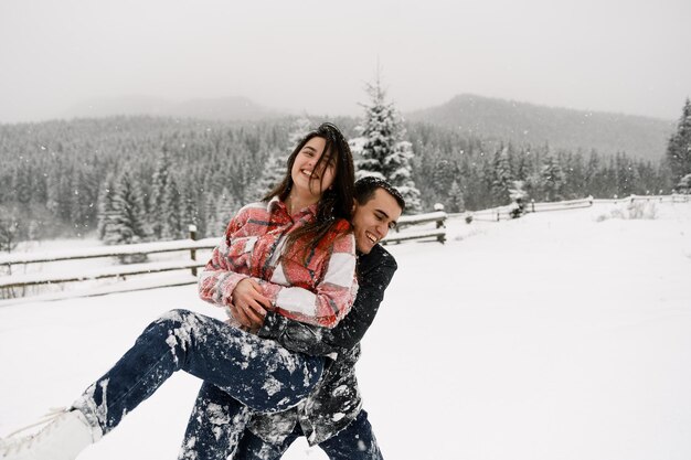 冬の散歩でシャツを着た愛情のあるカップル。凍りつくような森で楽しんでいる男女。冬のロマンチックなデート。若い家族のクリスマスムード。冬のラブストーリー