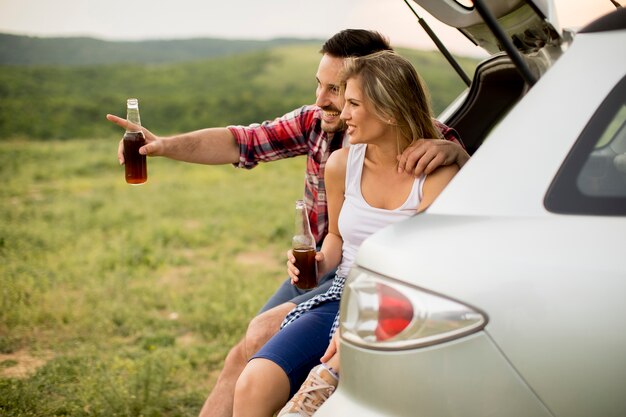 Loving couple sitting in the car trank