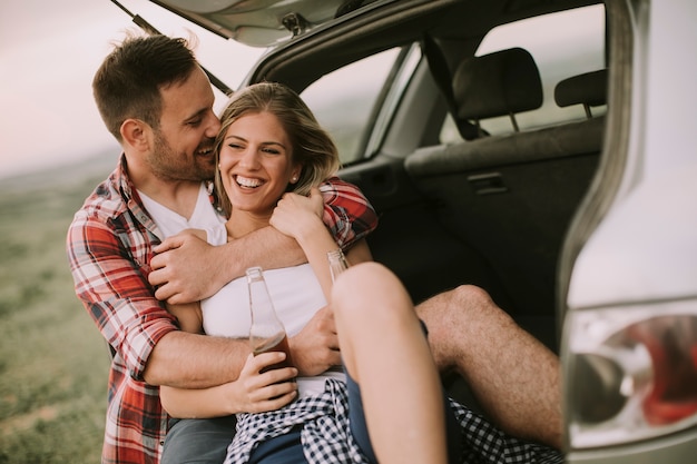 Loving couple sitting in the car trank