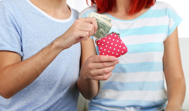 Loving couple sitting in sofa with purse in room