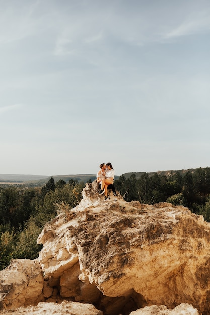 Loving couple sitting on the stones in the mountains.