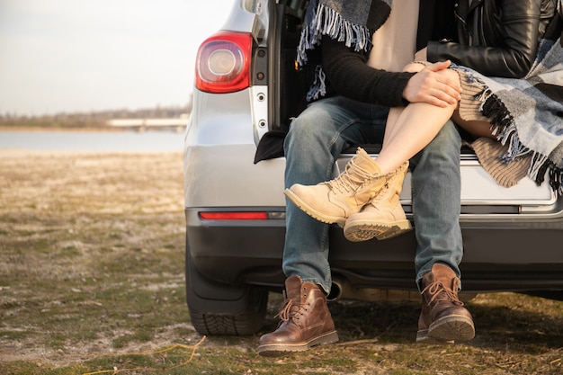 Photo loving couple sitting in the trunk of a car