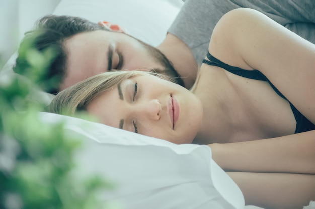 Loving couple sleeping in bed