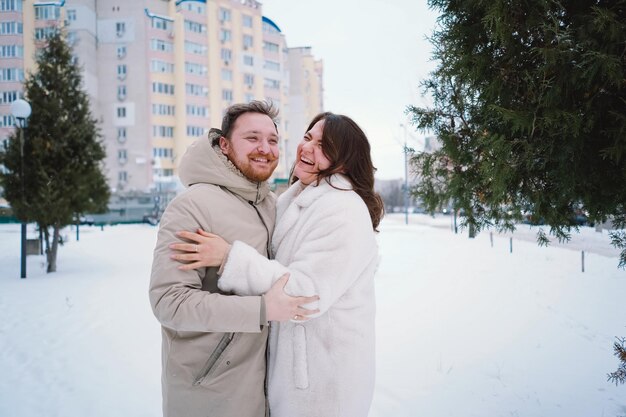 Loving couple on a snowy winter field happy together