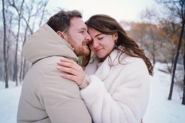 Loving couple on a snowy winter field happy together