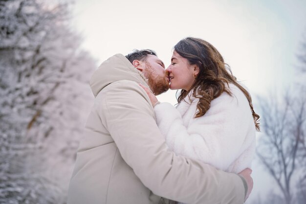 Loving couple on a snowy winter field happy together