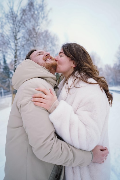 Любящая пара на снежном зимнем поле счастлива вместе