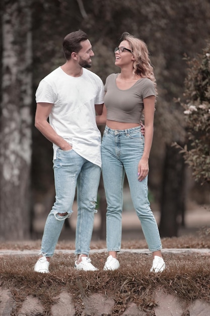 Loving couple standing on the grass near the lake in the Park