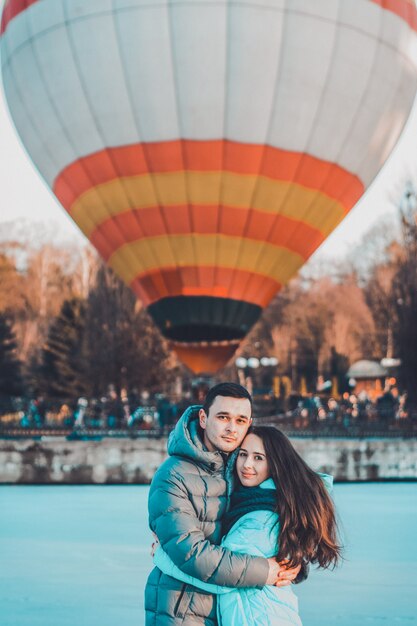 Loving couple stands on ice on Valentine's Day, behind the air ball.