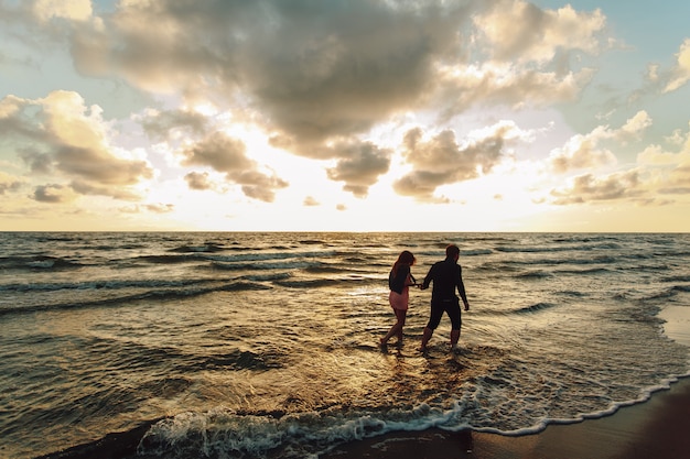 A loving couple strolls in the evening along the seashore