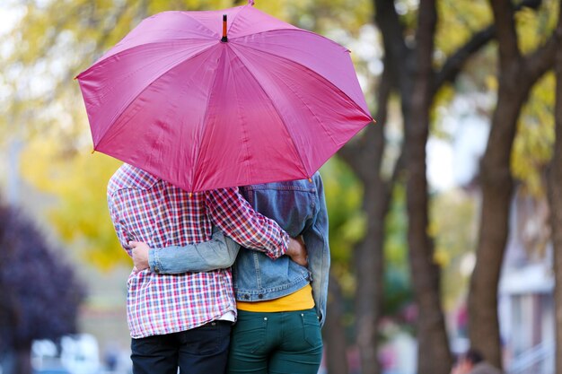 Loving couple under an umbrella in autumn park