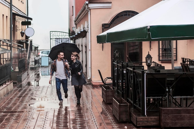 Loving couple under an umbrella walking down the street of the old city