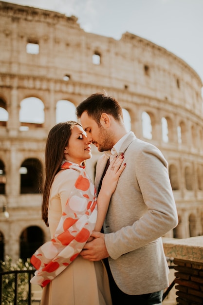 Loving couple visiting Italian famous landmarks Colosseum in Rome, Italy