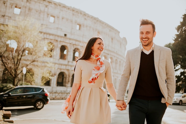 Loving couple visiting Italian famous landmarks Colosseum in Rome, Italy