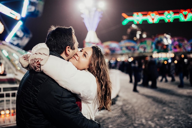 Una coppia di innamorati passeggia per la città di natale di sera in inverno.