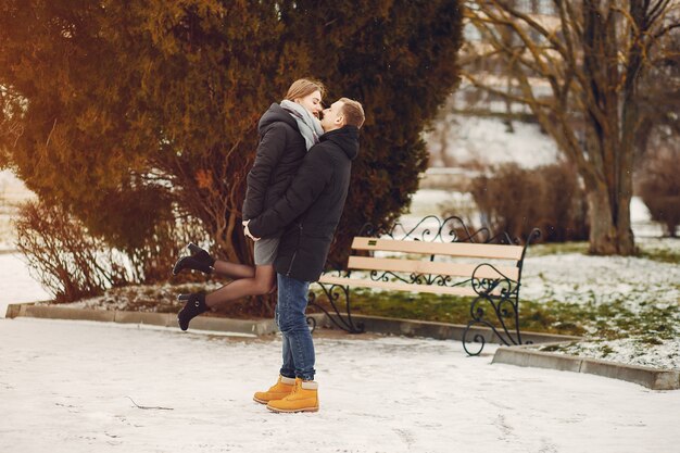 Amorevole coppia wallking in un parco innevato