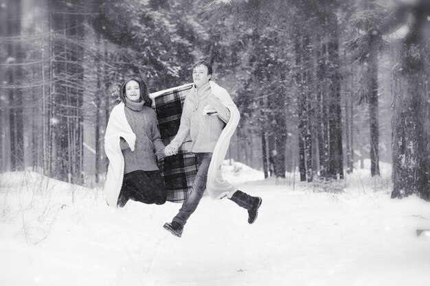 A loving couple on a winter walk. Man and woman on a date in the park in winter. Friends in a winter park