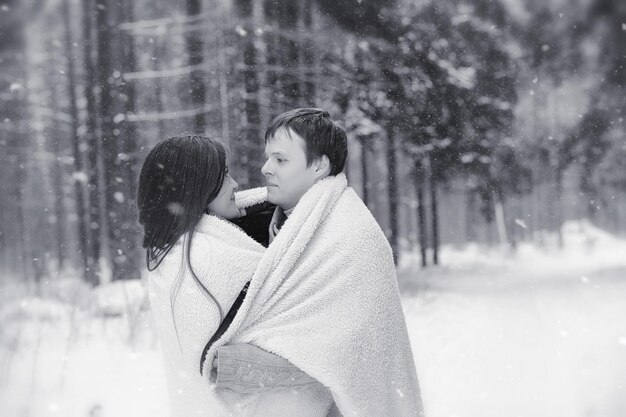 A loving couple on a winter walk Man and woman on a date in the park in winter Friends in a winter park