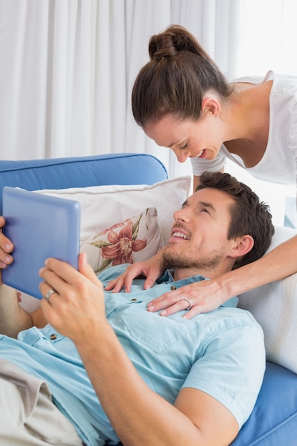 Loving couple with digital tablet in living room