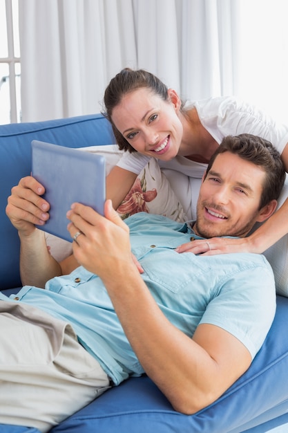 Loving couple with digital tablet in living room