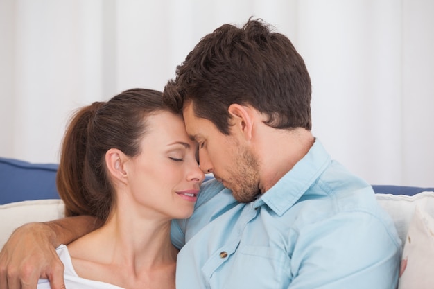 Loving couple with eyes closed on couch