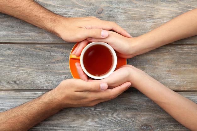 Loving couple with hot drink on table