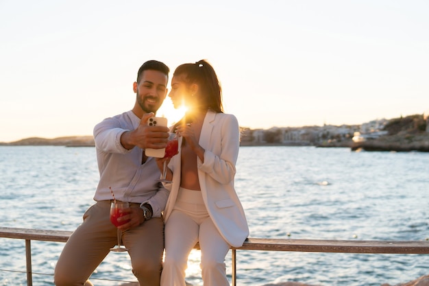 Loving ethnic couple taking self shot on seafront