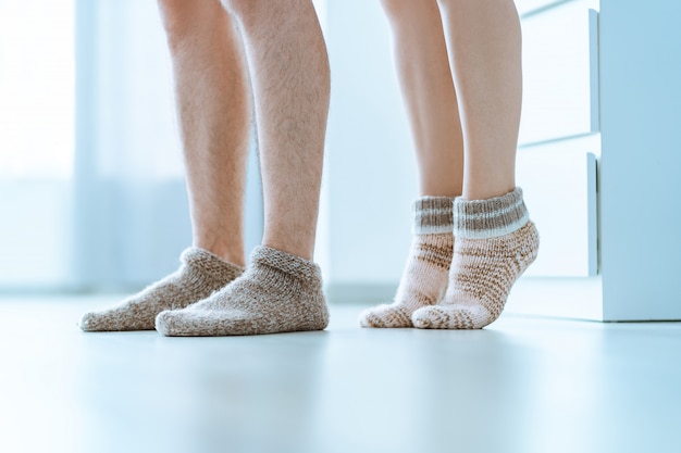 Любящие семейные пары вместе в уютных мягких теплых вязаных зимних носках в домашних условиях