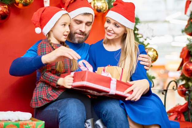 Famiglia amorevole con regali di natale nel centro commerciale