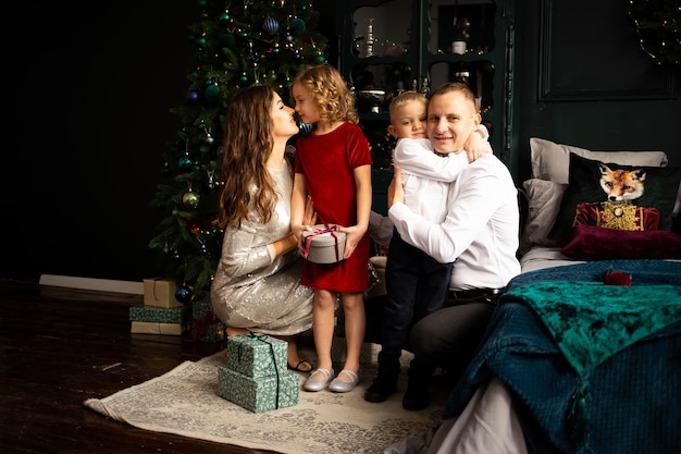 Photo loving family with presents in room merry christmas and happy holidays parents and their little child having fun indoors