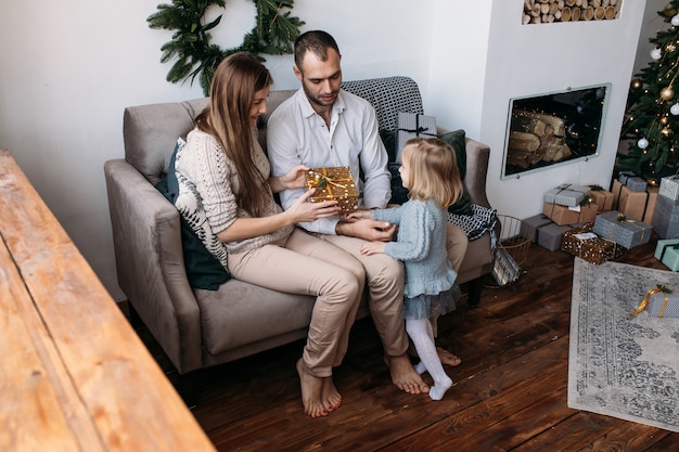 Loving family with presents in room. 