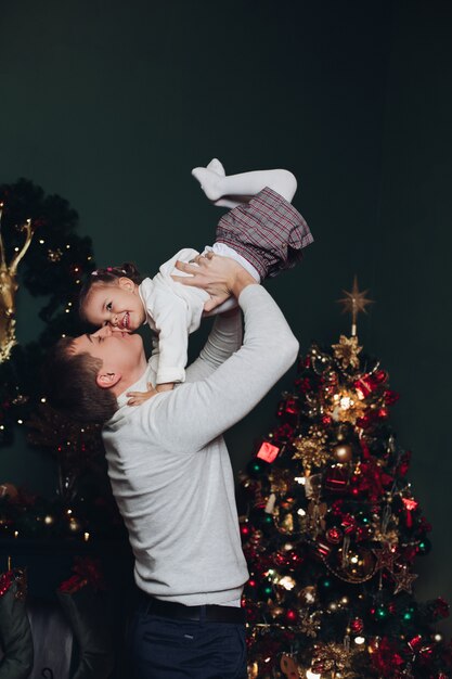 Любящий отец, играя со своей дочерью на Рождество.
