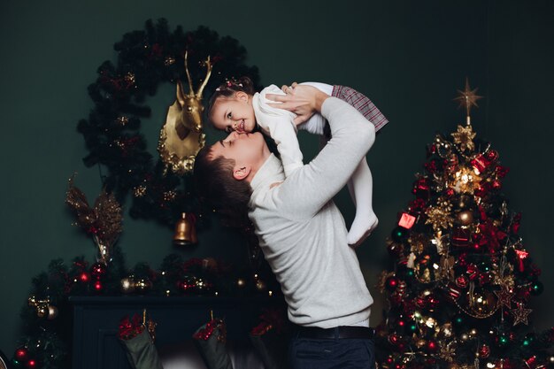 Photo loving father playing with his daughter at christmas.