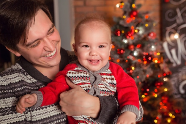 Loving father with son near Christmas tree smiling together