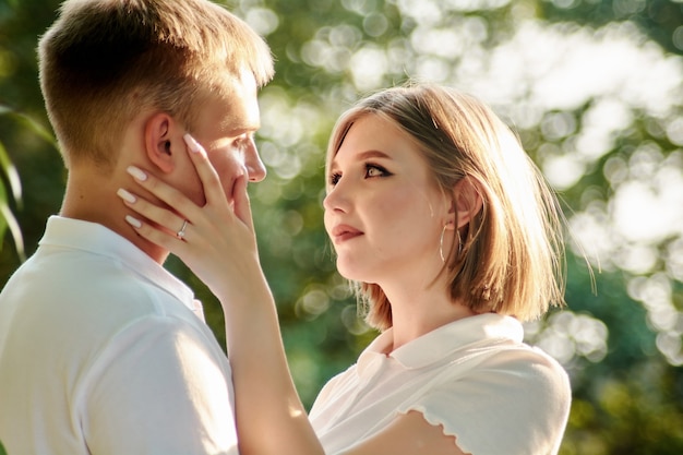 A loving guy and a girl are walking in the park. The concept of an outdoor love story.