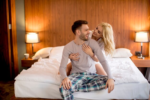 Loving and hugged couple on the bed in the room