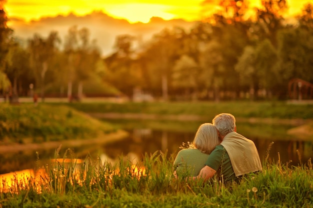 Loving mature couple  in summer park on the Sunset