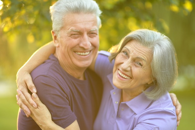 Loving mature couple  in summer park on the Sunset