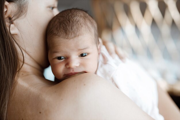 loving mom carying of her newborn baby at home