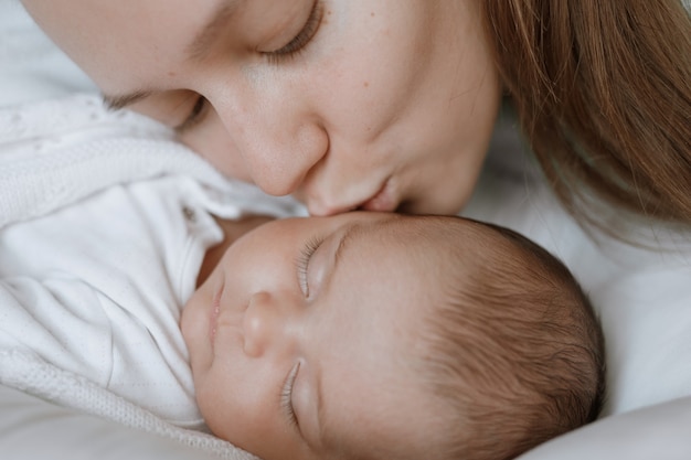 Loving mom carying of her newborn baby at home