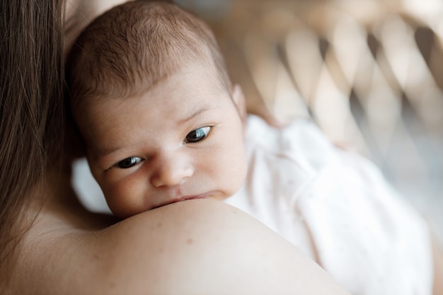 Loving mom carying of her newborn baby at home