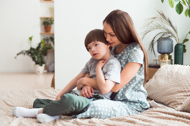 ダウン症の少年を抱きしめる愛情深い母親