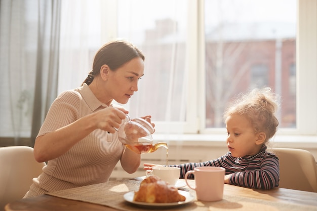 Loving Mother Enjoying Breakfast with Cute Little Daughter