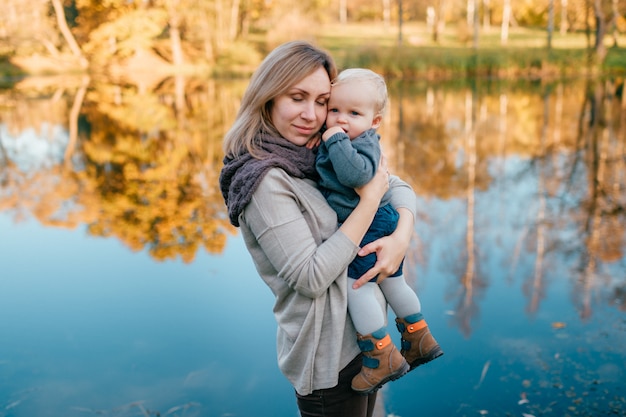 La madre amorevole abbraccia il suo bambino piccolo alla natura