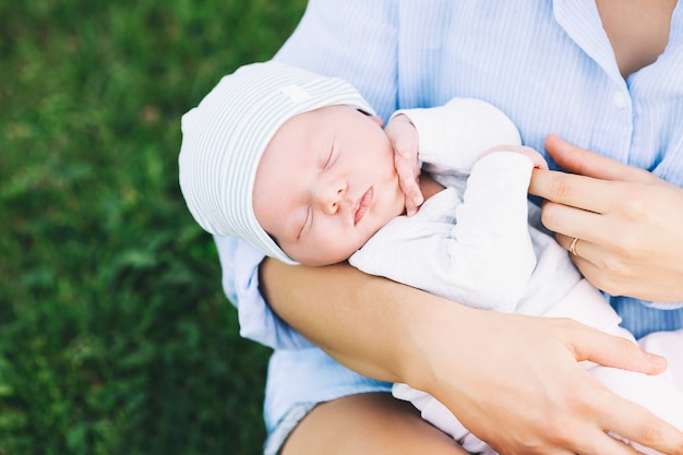 Loving mother with her newborn baby on her arms beautiful mom with newborn child on nature